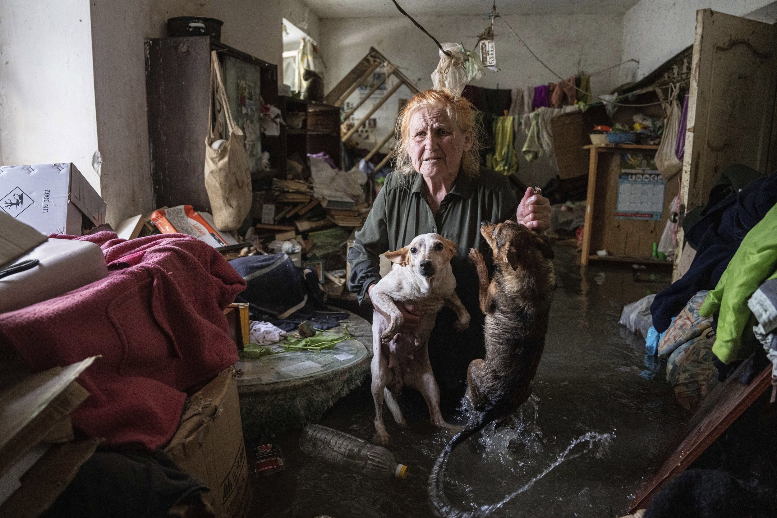  Tetiana holds her pet dogs, Tsatsa and Chunya, in her home that was flooded after the Kakhovka dam blew up overnight, in Kherson, Ukraine, on June 6, 2023. Ukraine accused Russian forces of blowing up the dam and hydroelectric power station, located