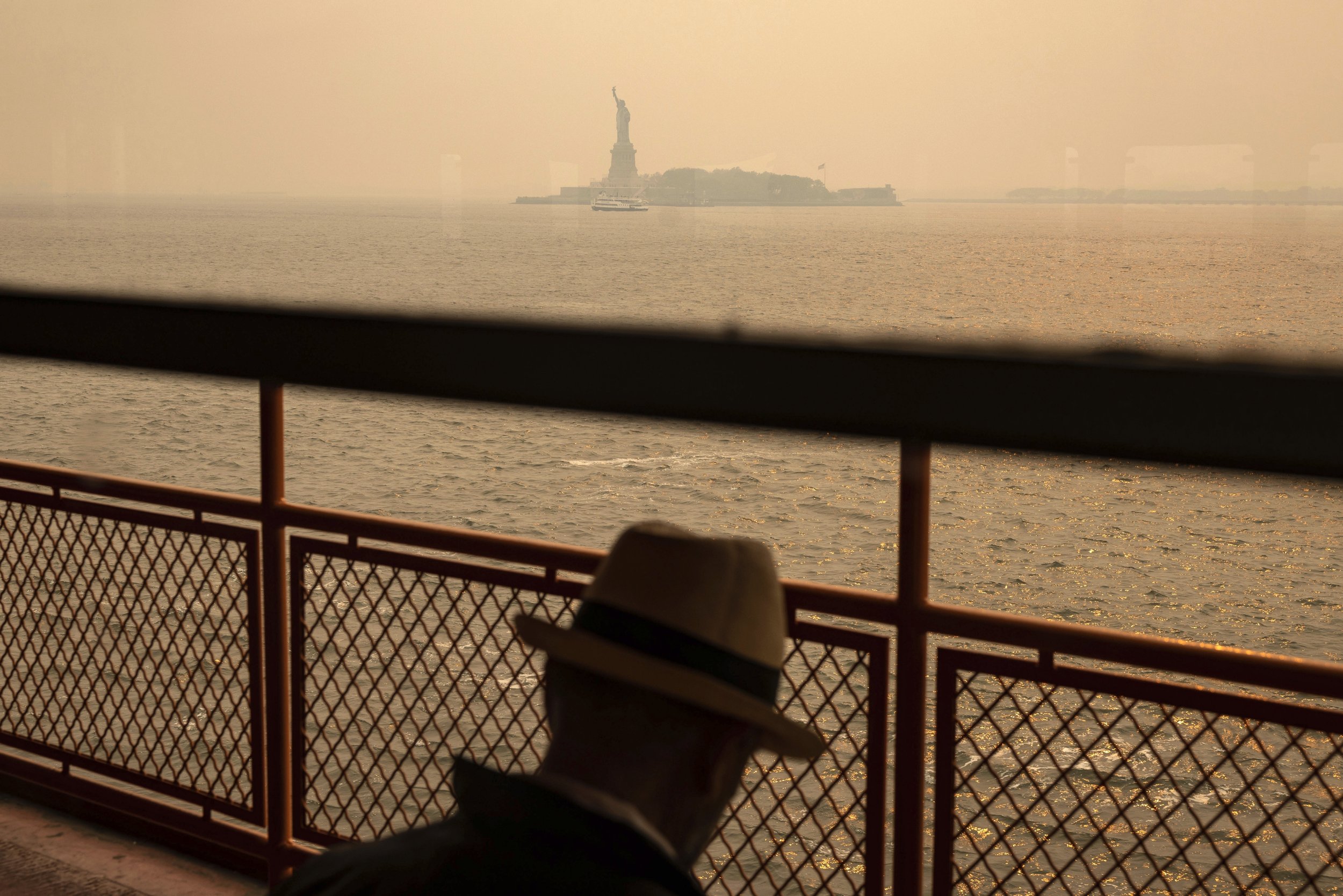  Smoke that drifted south from Canadian wildfires creates a think haze over New York Harbor as the Staten Island Ferry passes the Statue of Liberty on June 7, 2023. (AP Photo/Yuki Iwamura) 