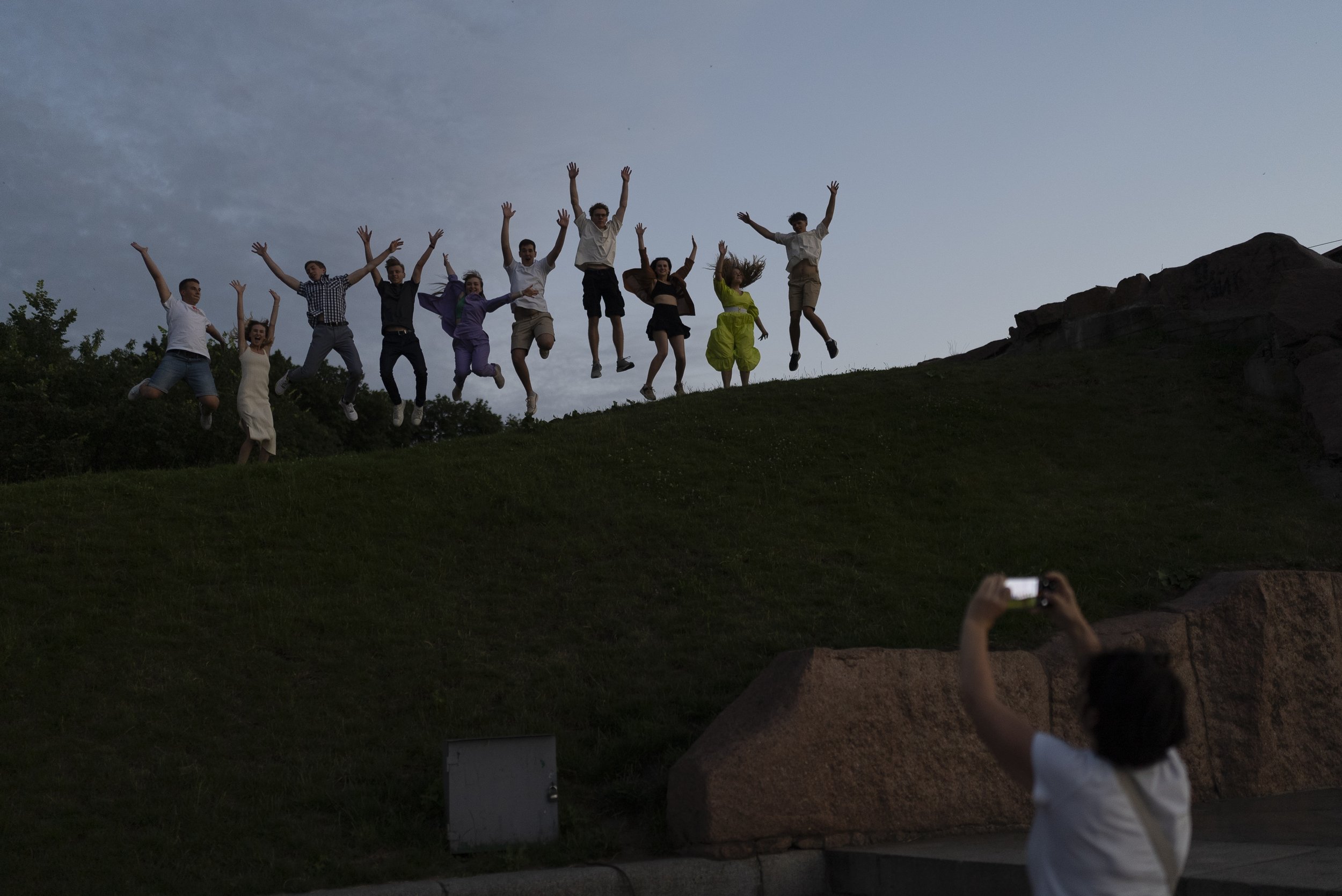  A group of recent high school grads leap as they pose for photos to celebrate their graduation in Kyiv, Ukraine, on July 3, 2023. (AP Photo/Jae C. Hong) 