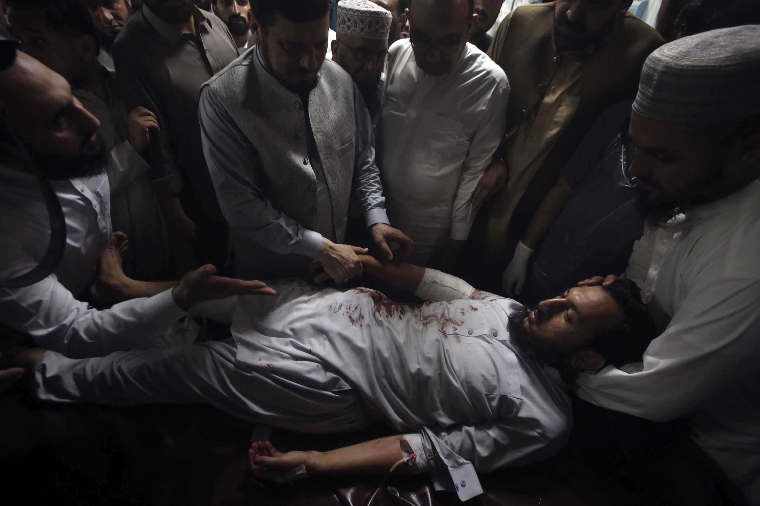 Relatives of an injured victim of a powerful bomb stand around his bed at a hospital in Peshawar, Pakistan, on July 30, 2023. Earlier that day, the bomb ripped through a rally of supporters of a hard-line cleric and political leader in the country's