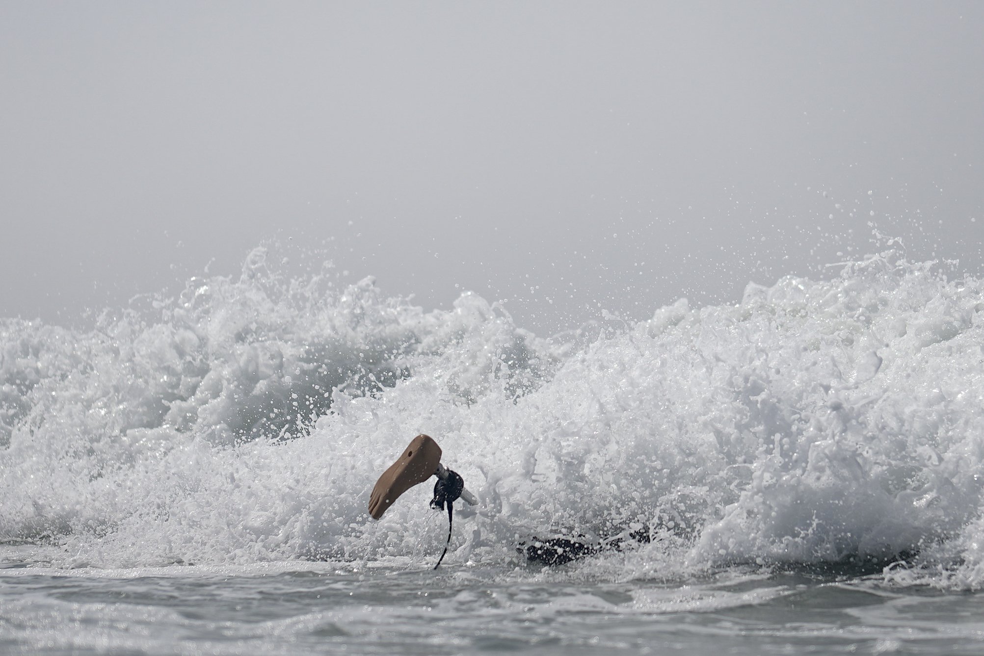  Chris Blowes, of Australia, duck-dives under a wave during the U.S. Open Adaptive Surfing Championships in Oceanside, Calif., on Sept. 8, 2023. More than 100 athletes with disabilities from 17 countries competed in the event. (AP Photo/Gregory Bull)