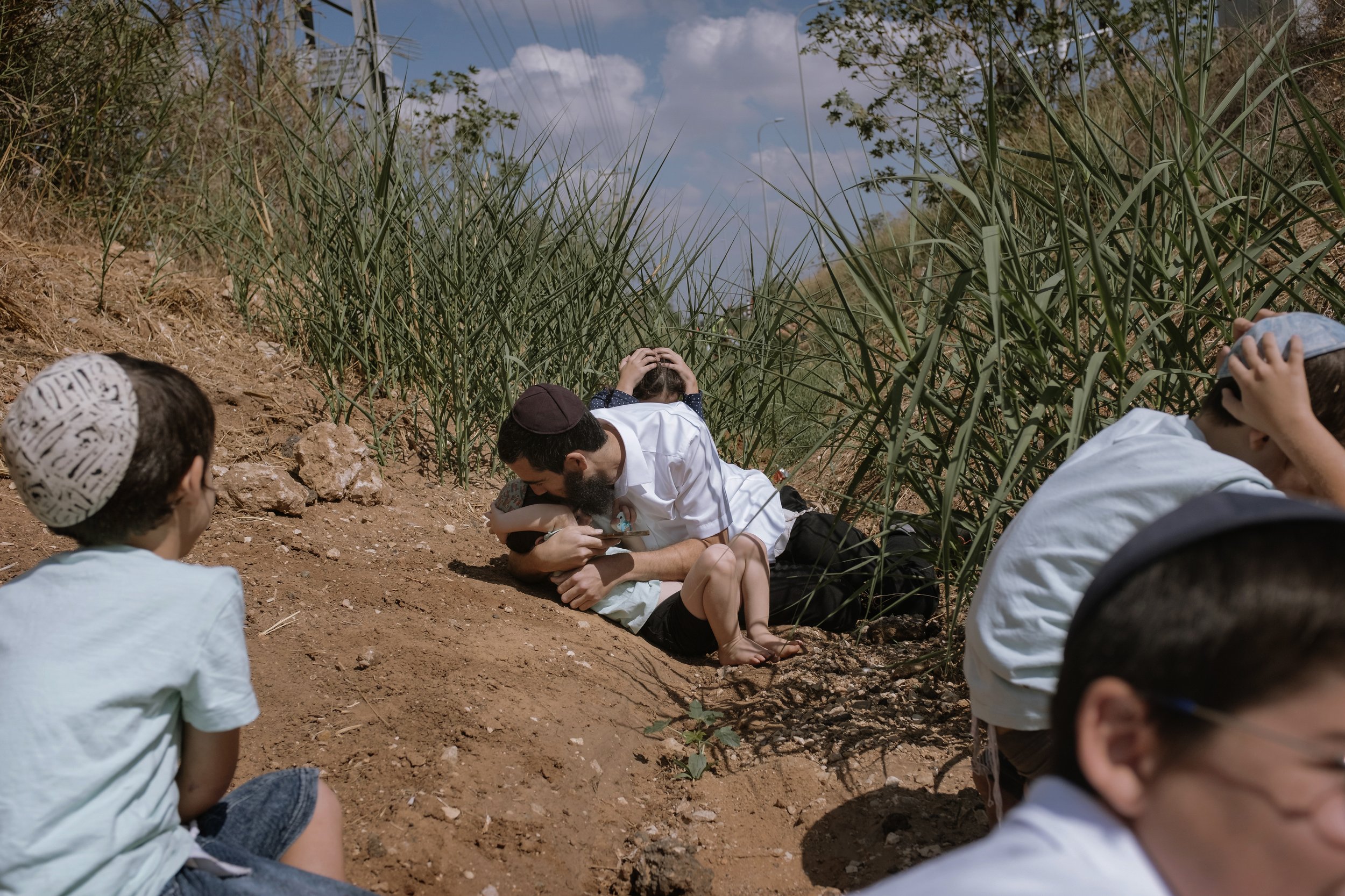  Israelis take cover as a siren sounds a warning of incoming rockets fired from the Gaza Strip in Rehovot, Israel, on Oct. 13, 2023. (AP Photo/Dor Kedmi) 