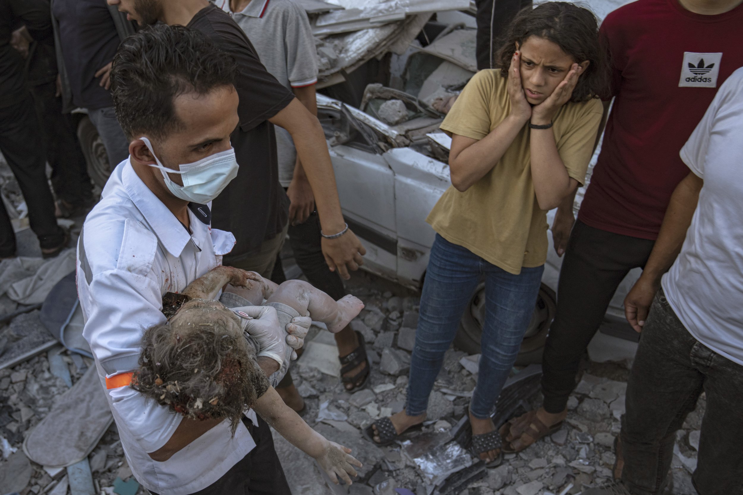  A Palestinian girl reacts as a child is carried from the rubble of a building after an airstrike in Khan Younis, Gaza Strip, on Oct. 21, 2023. (AP Photo/Fatima Shbair) 