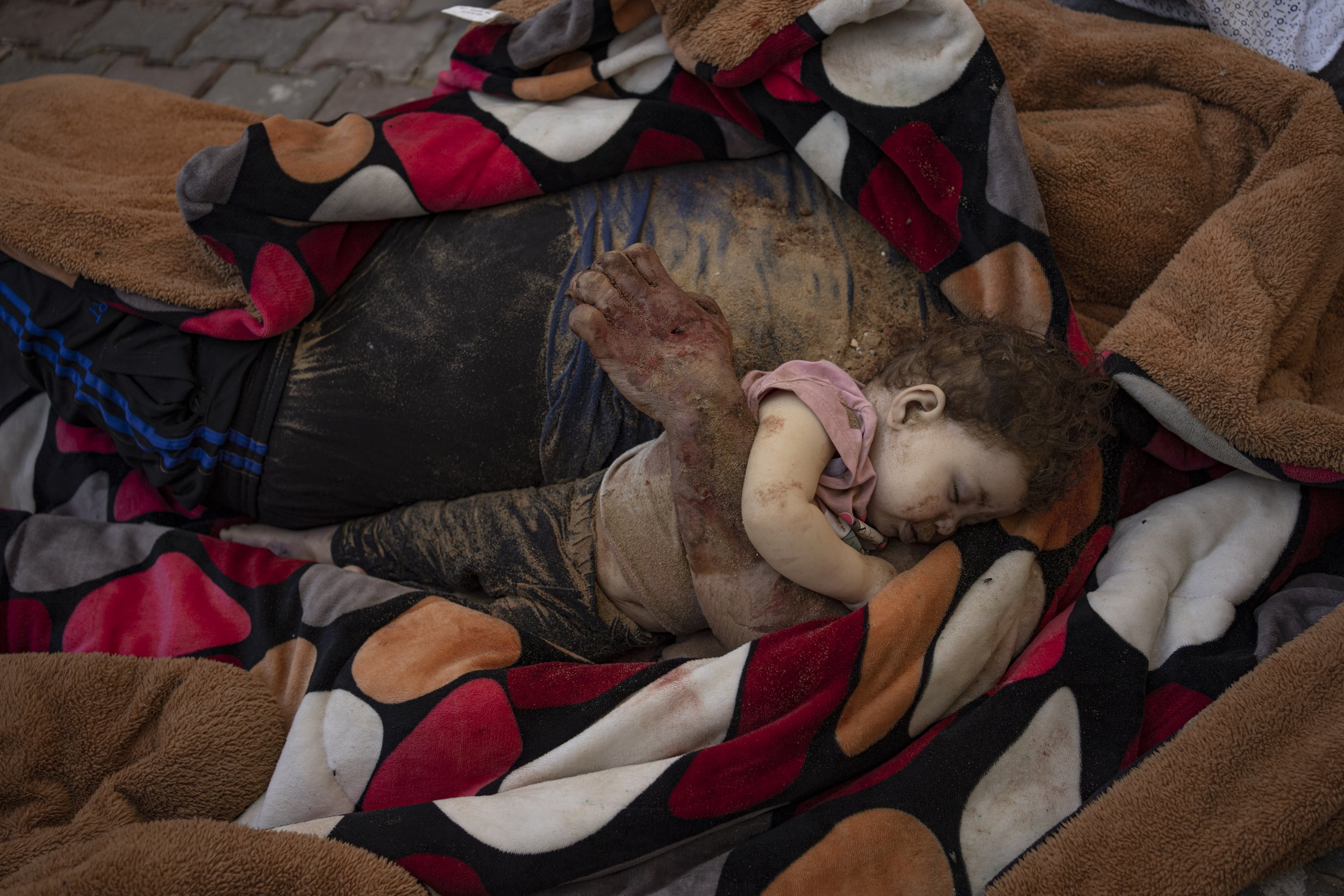  The bodies of a father and his child, killed in the Israeli bombardment of the Gaza Strip, lie in front of the morgue at Al-Aqsa Hospital in Deir Al-Balah on Oct. 22, 2023. ( AP Photo/Fatima Shbair) 