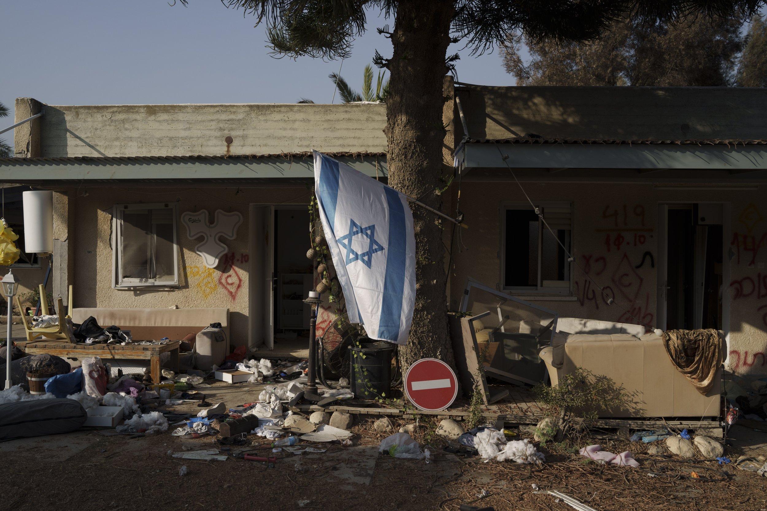  An Israeli flag hangs between destroyed homes in kibbutz Kfar Azza, Israel, near the Gaza Strip, on Nov. 13, 2023. The kibbutz was attacked during the Hamas cross-border attack on Oct. 7, killing and capturing members of its community. (AP Photo/Leo
