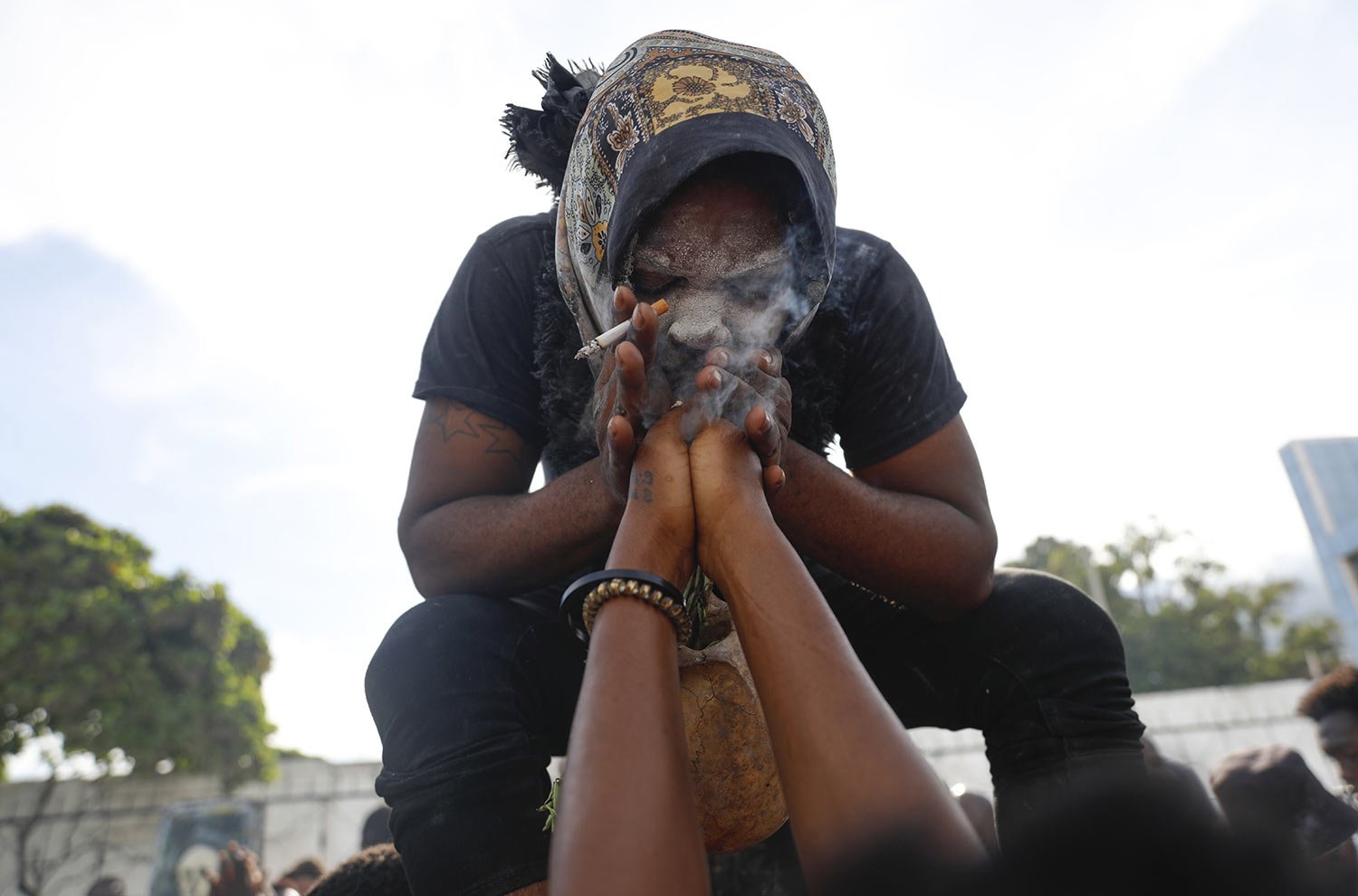  A voodoo believer possessed with a Gede spirit performs a cleansing for a woman during Day of the Dead celebrations at the National Cemetery in Port-au-Prince, Haiti, Nov. 1, 2023. (AP Photo/Odelyn Joseph) 