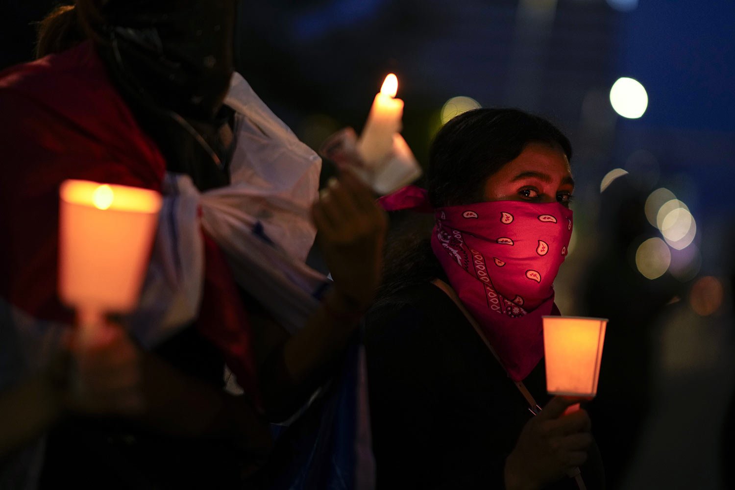  A woman holds a candle during a vigil at a protest against a recently approved mining contract between the government and Canadian mining company First Quantum in Panama City, Nov. 8, 2023. (AP Photo/Arnulfo Franco) 