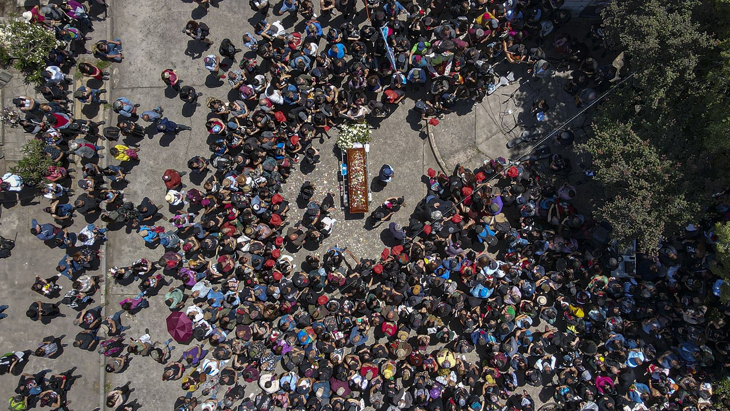  People toss flower petals on the hearse carrying the remains of British-Chilean dancer and human rights activist Joan Jara during a funeral procession in Santiago, Chile, Nov. 15, 2023. (AP Photo/Esteban Felix) 
