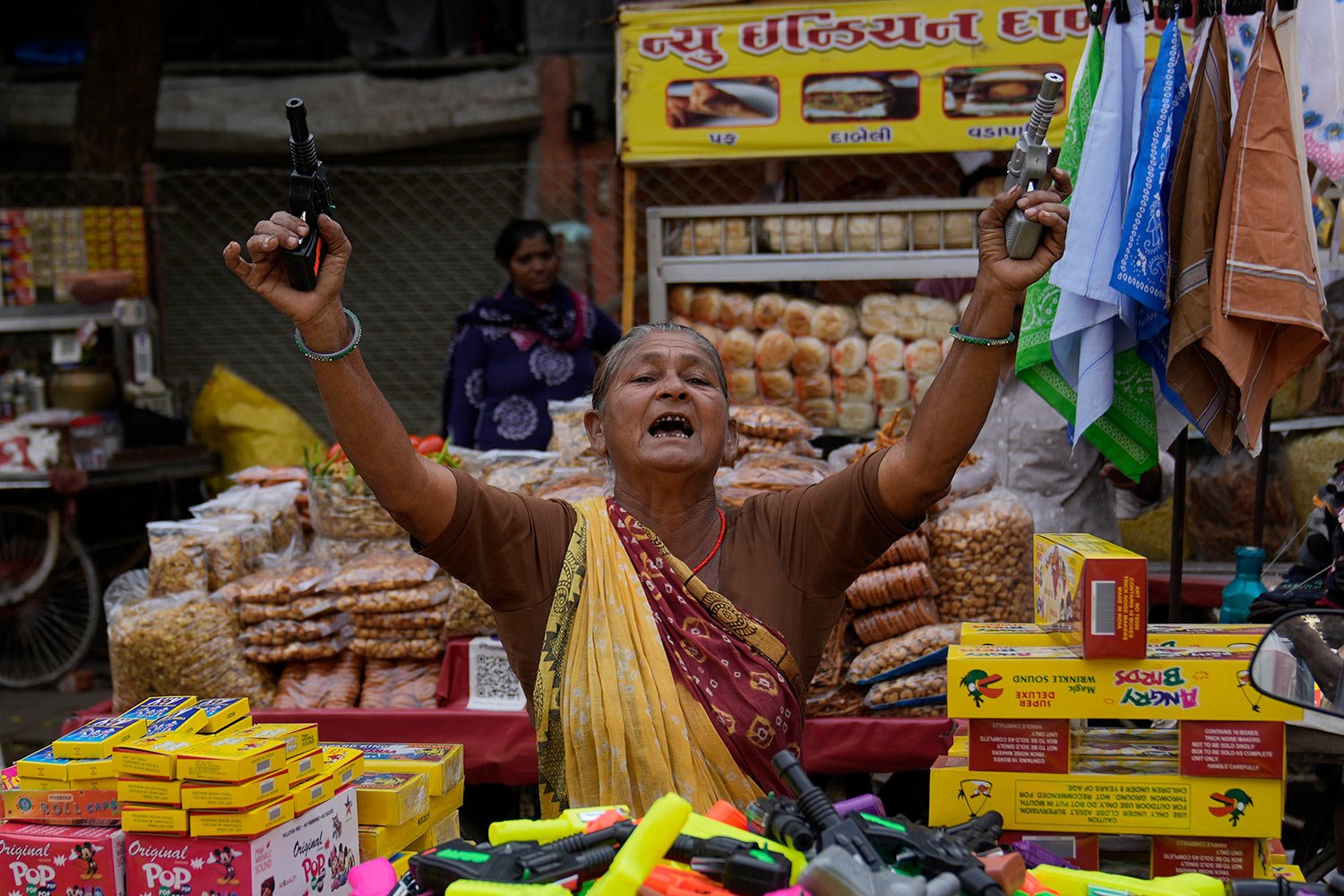  A street vendor woman selling firecracker toy guns tries to attract customers in Ahmedabad, India, Sunday, Nov. 5, 2023. (AP Photo/Mahesh Kumar A.) 