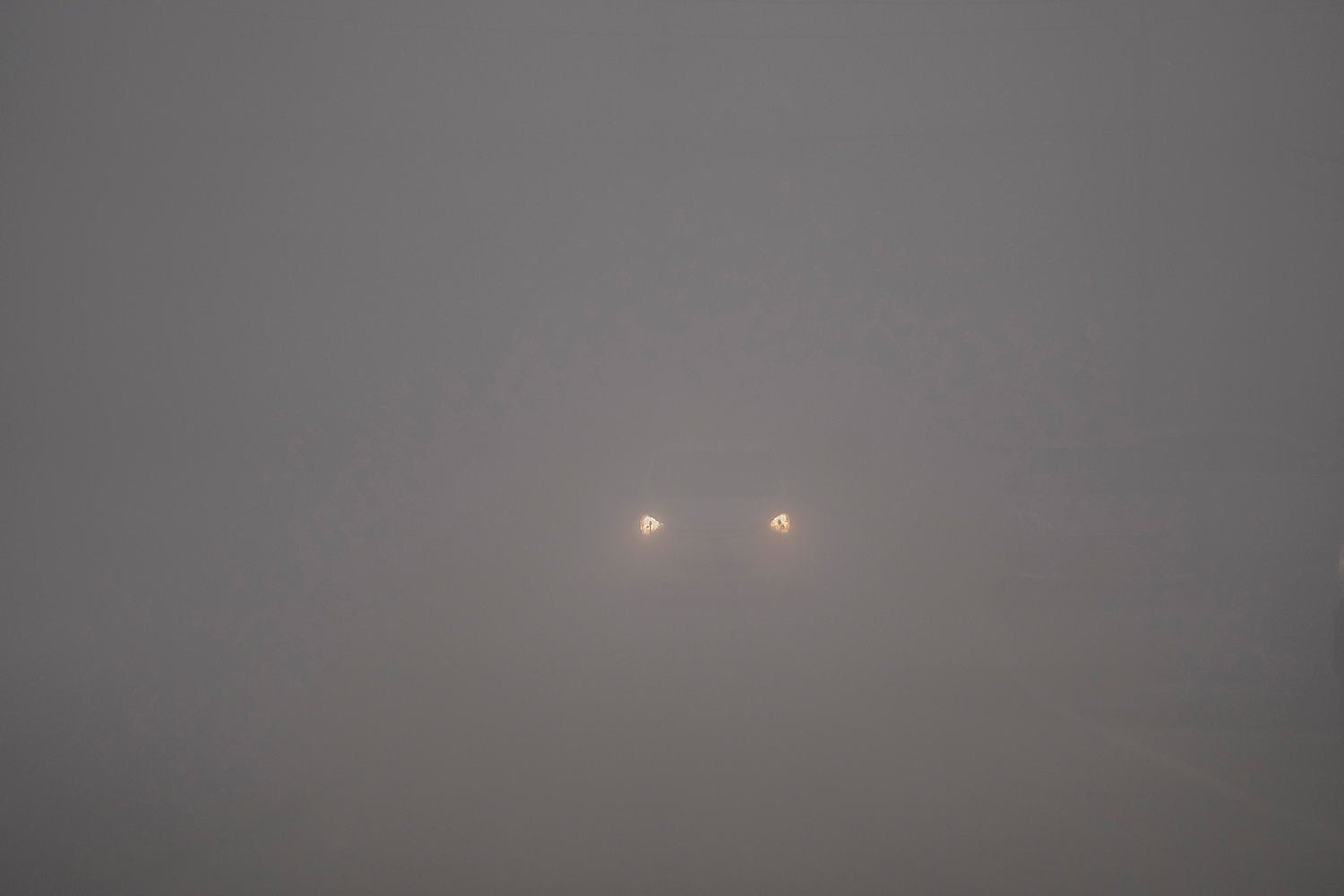  The headlights of a car are visible through dense fog on a cold morning in Srinagar, Indian controlled Kashmir, Wednesday, Nov. 15, 2023. (AP Photo/Mukhtar Khan) 