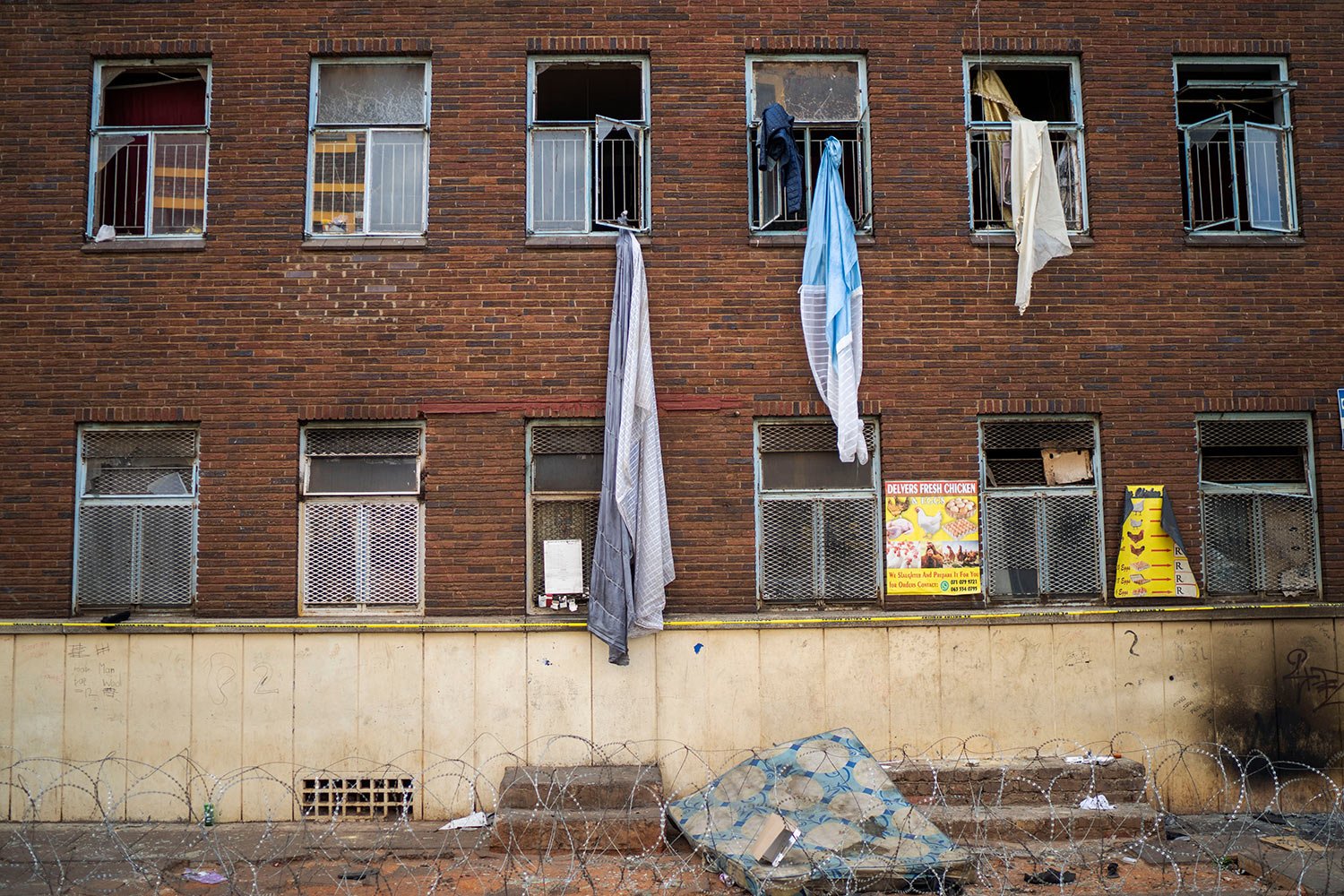  Curtains and sheets used by people trying to flee one of South Africa's deadliest inner-city fires dangle from windows, in Johannesburg, South Africa, Friday, Sept. 1, 2023. (AP Photo/Jerome Delay) 