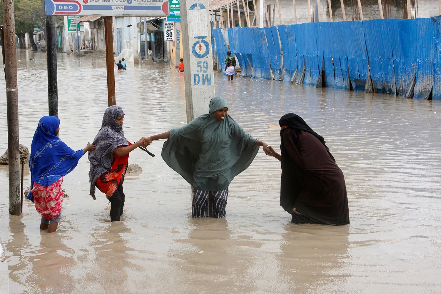  Women walk through flood water after heavy rainfall, in Mogadishu Somalia, Monday, Nov. 20, 2023. (AP Photo/Farah Abdi Warsameh) 