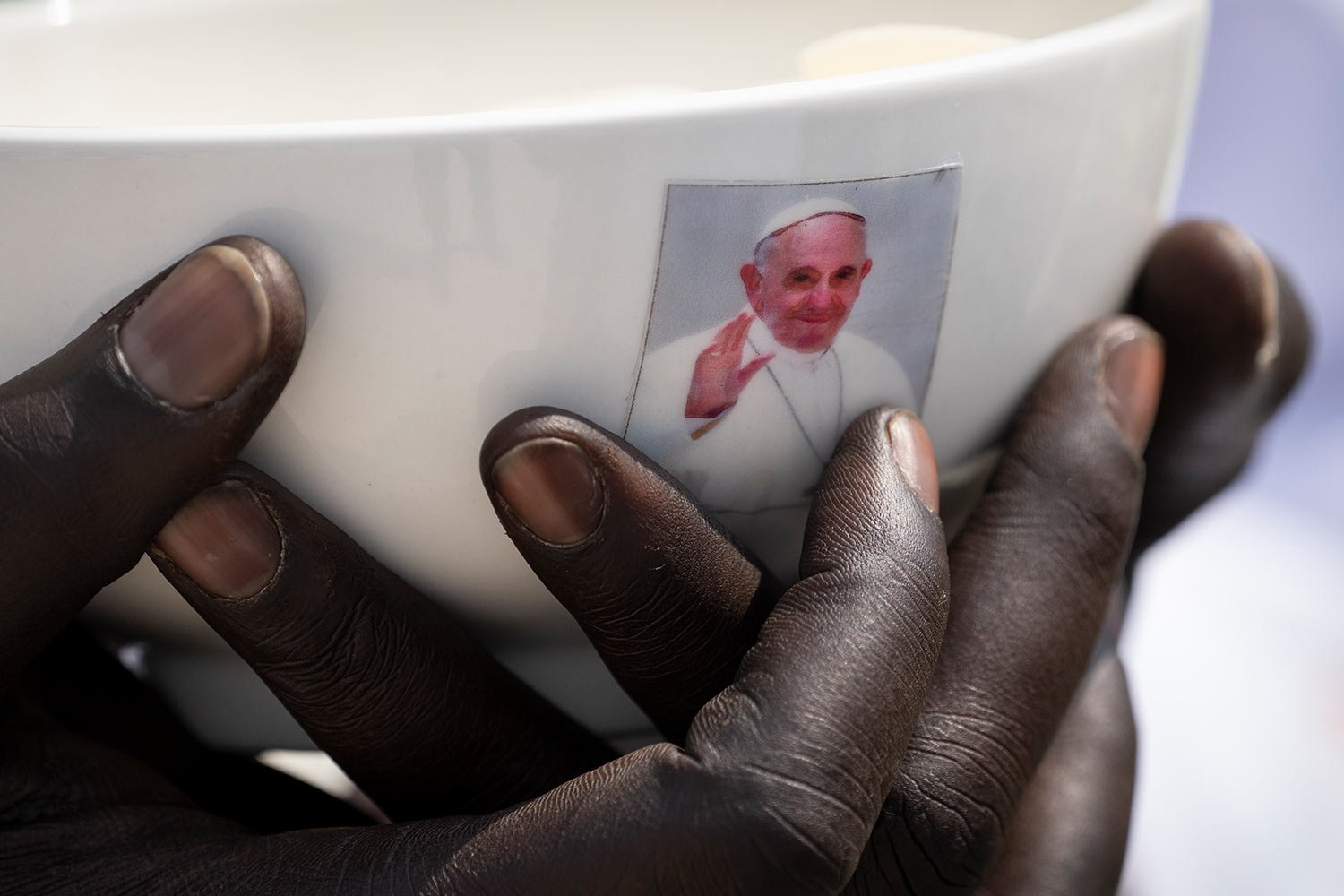  A priest holds a sacrament bowl showing a photograph of Pope Francis at a Holy Mass at the John Garang Mausoleum in Juba, South Sudan Sunday, Feb. 5, 2023.  (AP Photo/Ben Curtis) 