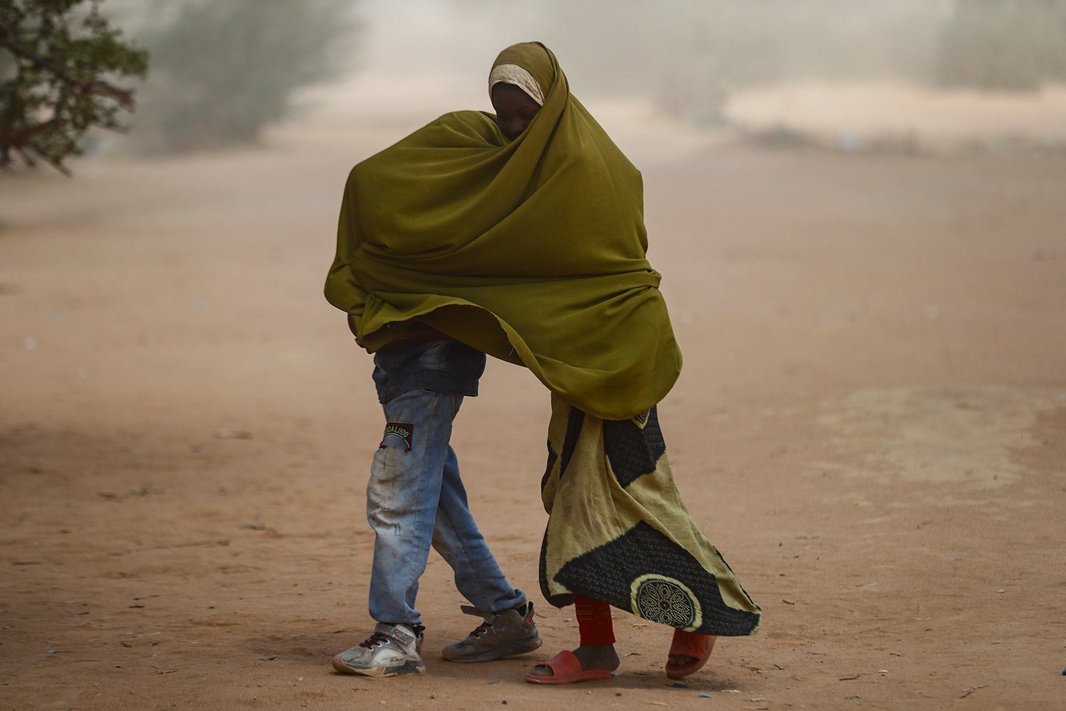  Somali refugee children cover as a dust storm moves across the Dadaab refugee camp in northern Kenya, Thursday, July 13, 2023.  (AP Photo/Brian Inganga) 