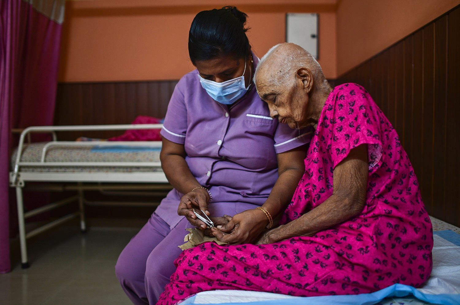  Mini, a nurse, trims the nails of Saradammal at the Signature Aged Care in Kochi, Kerala state, India, March 6, 2023.  (AP Photo/ R S Iyer) 