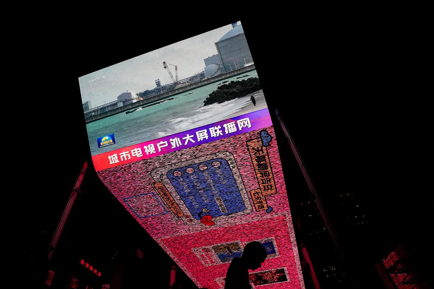  A man walks by a large screen at a shopping mall showing CCTV broadcasting news of Fukushima Daiichi nuclear power plant began releasing its first batch of treated radioactive water into the Pacific Ocean, in Beijing, Thursday, Aug. 24, 2023. (AP Ph