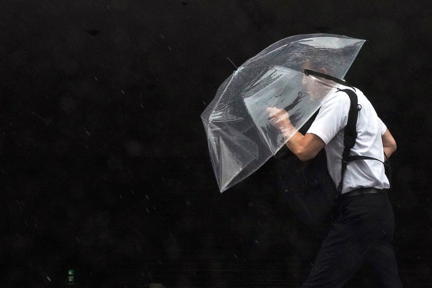  A man holds an umbrella against strong wind and rain as he walks on a street Friday, June 2, 2023, in Tokyo, as a tropical storm was approaching. (AP Photo/Eugene Hoshiko) 