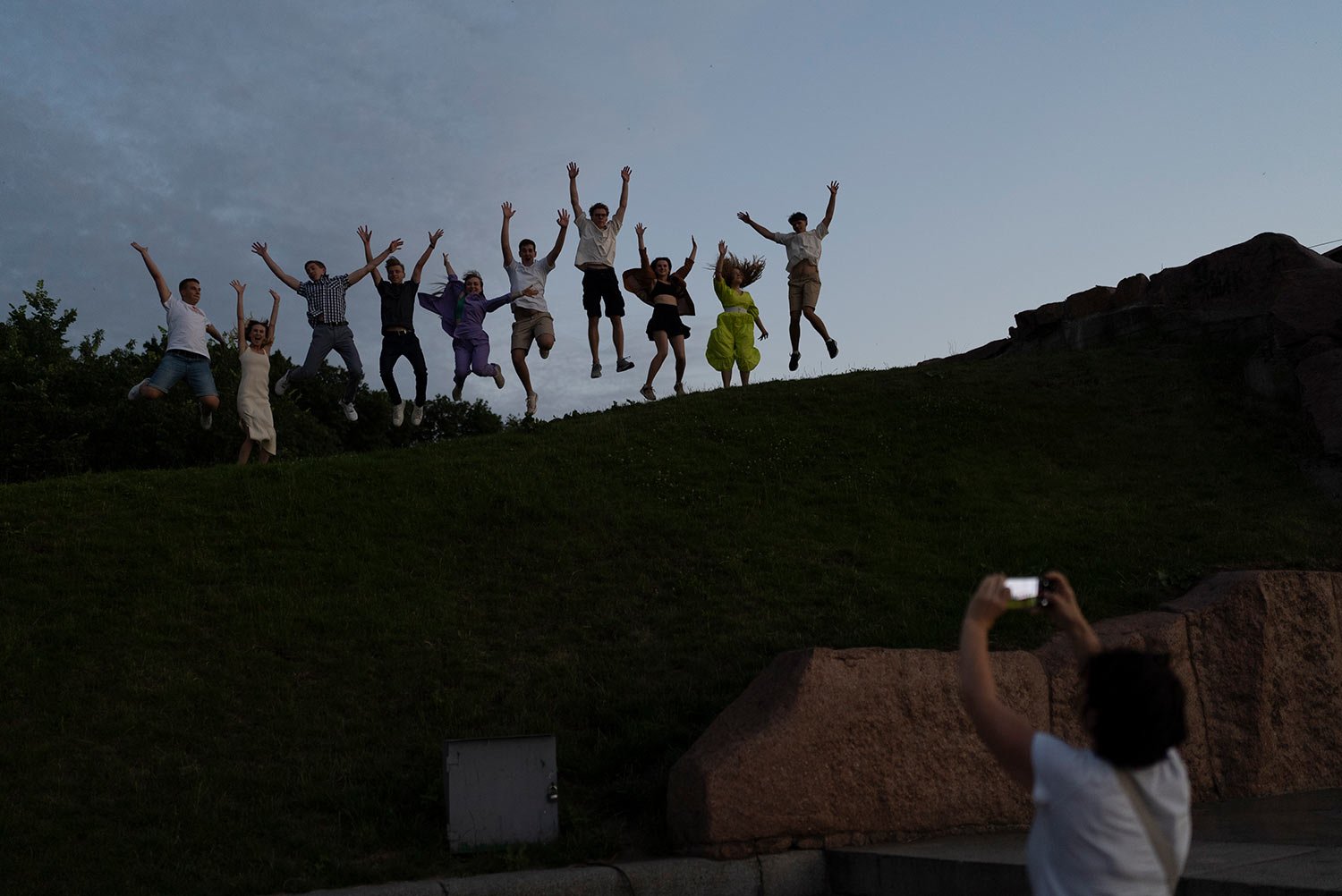  A group of recent high school grads leap as they pose for photos to celebrate their graduation in Kyiv, Ukraine, Monday, July 3, 2023. (AP Photo/Jae C. Hong) 