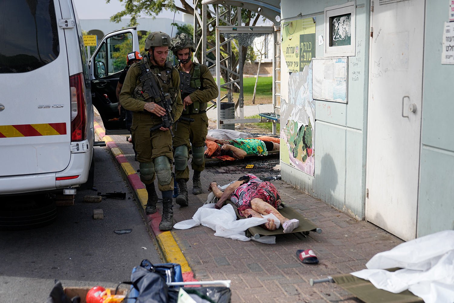  Israeli soldiers walk by civilians killed by Palestinian militants in Sderot, Israel, on Saturday, Oct. 7, 2023.  (AP Photo/Ohad Zwigenberg) 