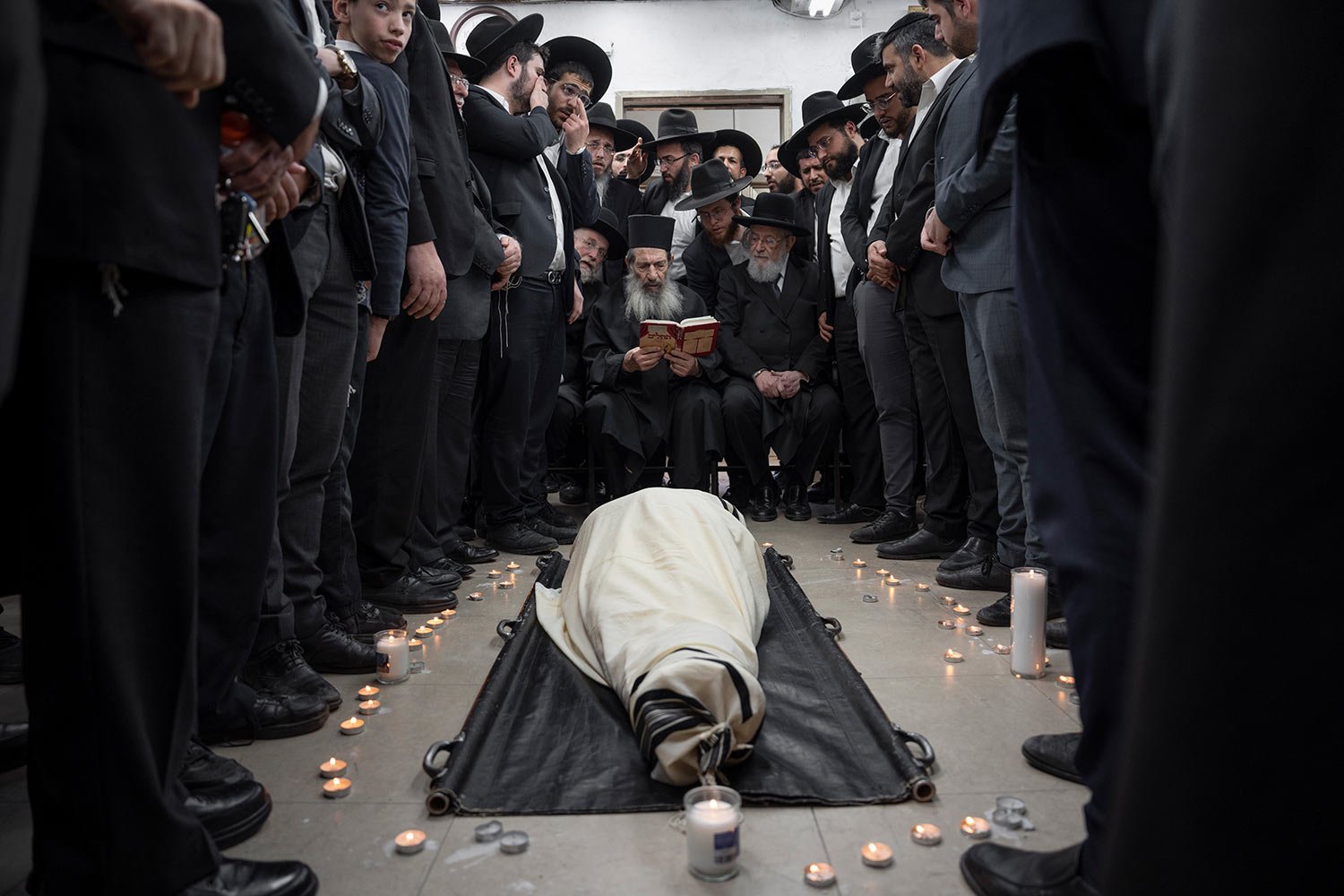  Ultra-Orthodox Jews mourn over the body of Rabbi Shimon Baadani during his funeral, in Bnei Brak, Israel, Wednesday, Jan. 11, 2023. (AP Photo/Oded Balilty) 