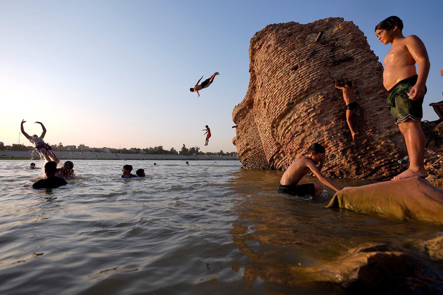  Iraqis swim in the Tigris River in Baghdad, Iraq, Thursday, July 13, 2023. (AP Photo/Hadi Mizban) 