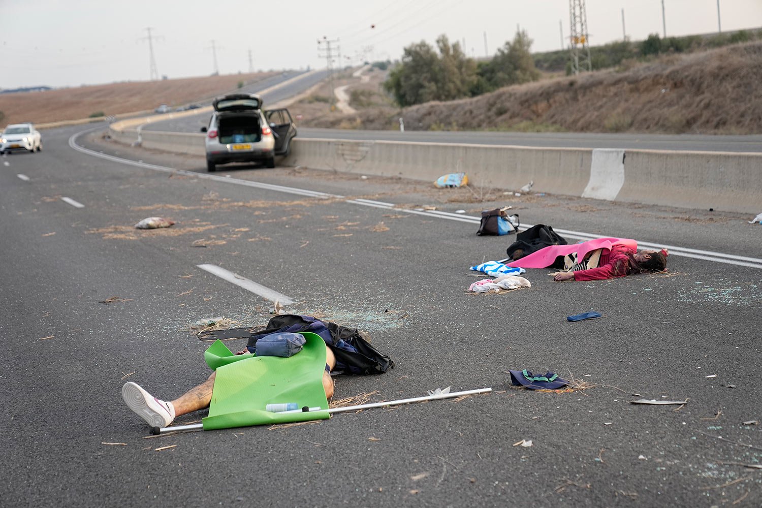  Israelis killed by Hamas militants lie on the road near Sderot, Israel, on Saturday, Oct. 7, 2023. (AP Photo/Ohad Zwigenberg) 