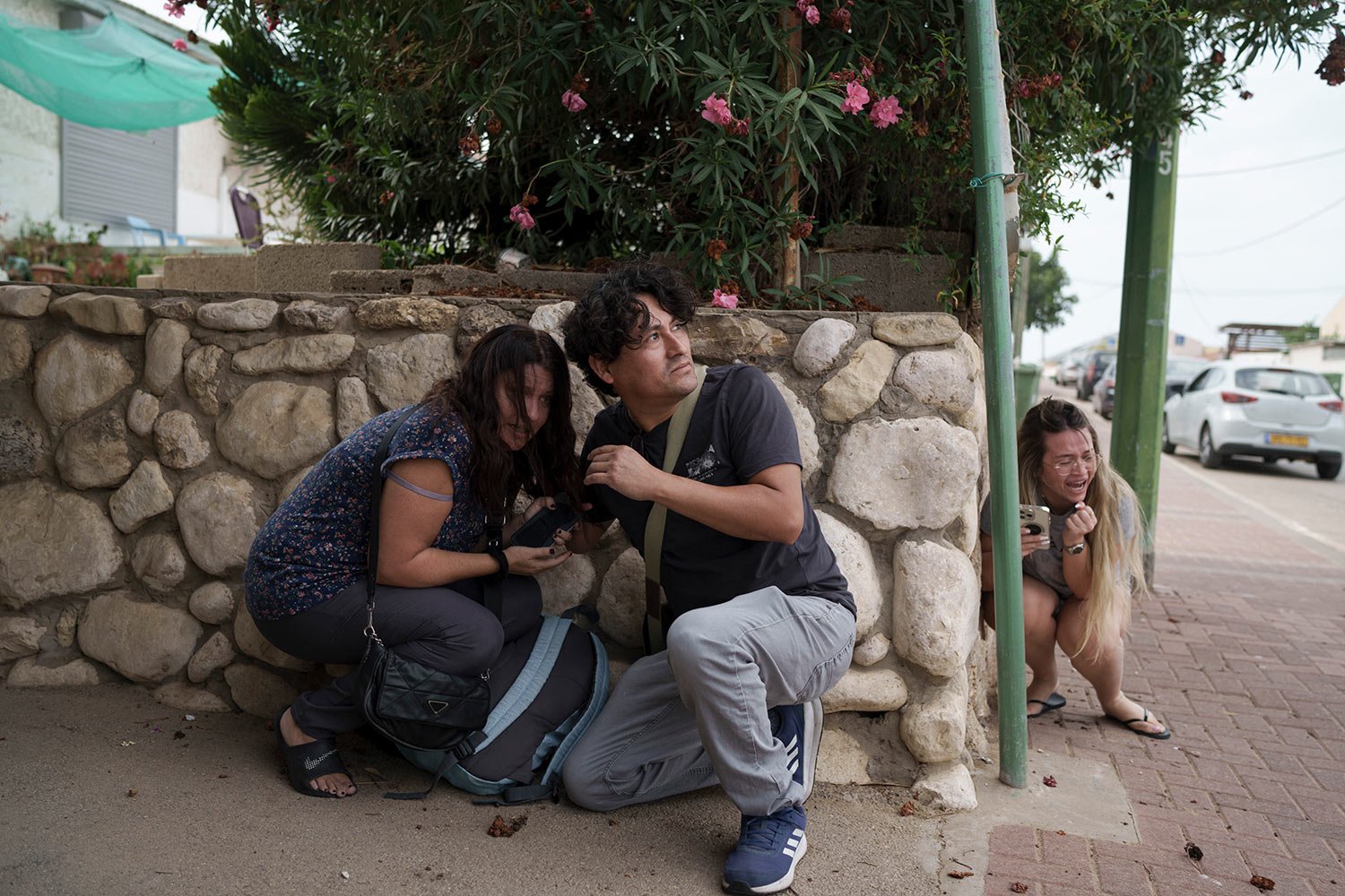  Israelis take cover from the incoming rocket fire from the Gaza Strip in Ashkelon, southern Israel, Wednesday, Oct. 11, 2023. (AP Photo/Leo Correa) 