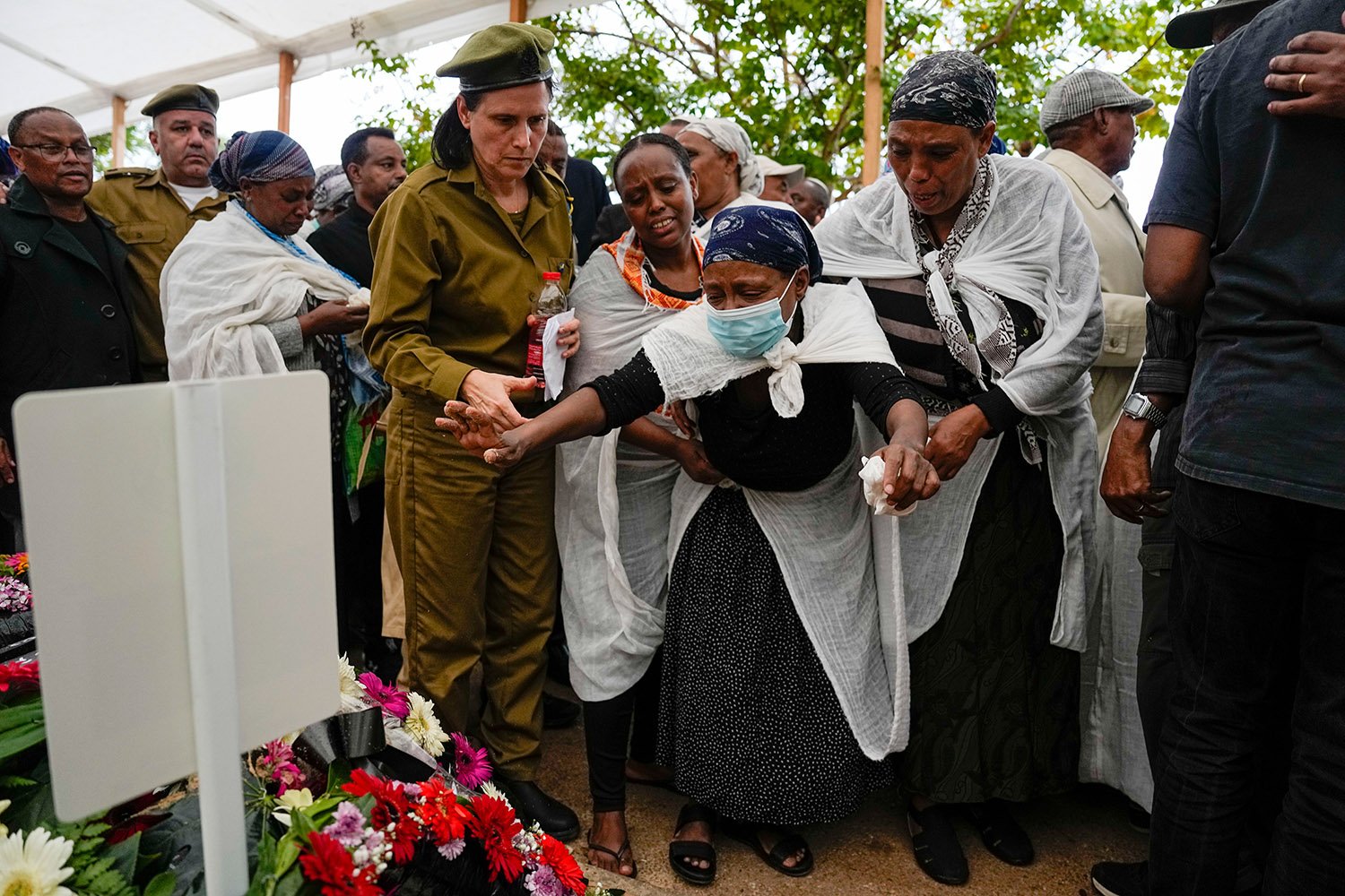  Family of Israeli soldier Corporal Avraham Fetena mourn over his grave during his funeral in Haifa, northern Israel, Friday, Nov. 17, 2023. Fetena, 20, was killed and six people were wounded in a shooting attack by three Palestinians at the checkpoi