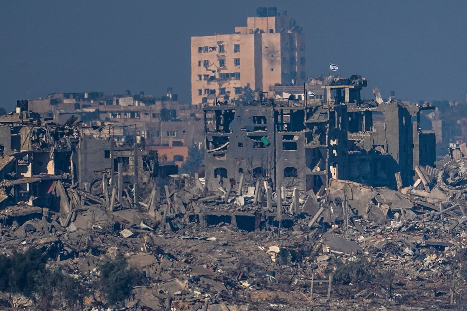  Israeli flags stand on the top of destroyed buildings in the Gaza Strip, as seen from southern Israel on Saturday, Nov. 18, 2023. (AP Photo/Ariel Schalit) 
