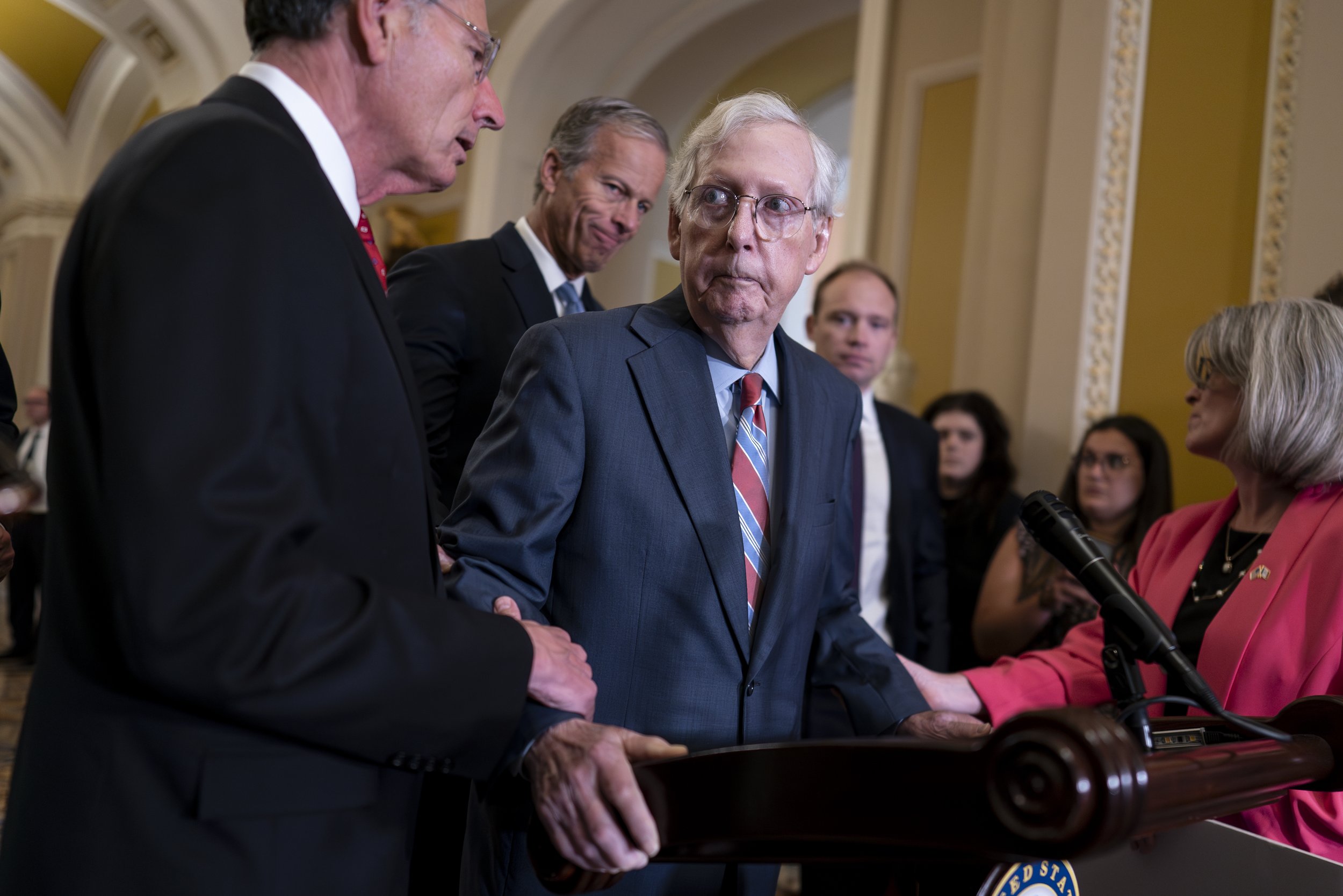 U.S. Senate Minority Leader Mitch McConnell, R-Ky., center, is helped by, from left, Sen. John Barrasso, R-Wyo., Sen. John Thune, R-S.D., and Sen. Joni Ernst, R-Iowa, after the 81-year-old GOP leader froze at the microphones as he arrived for a news