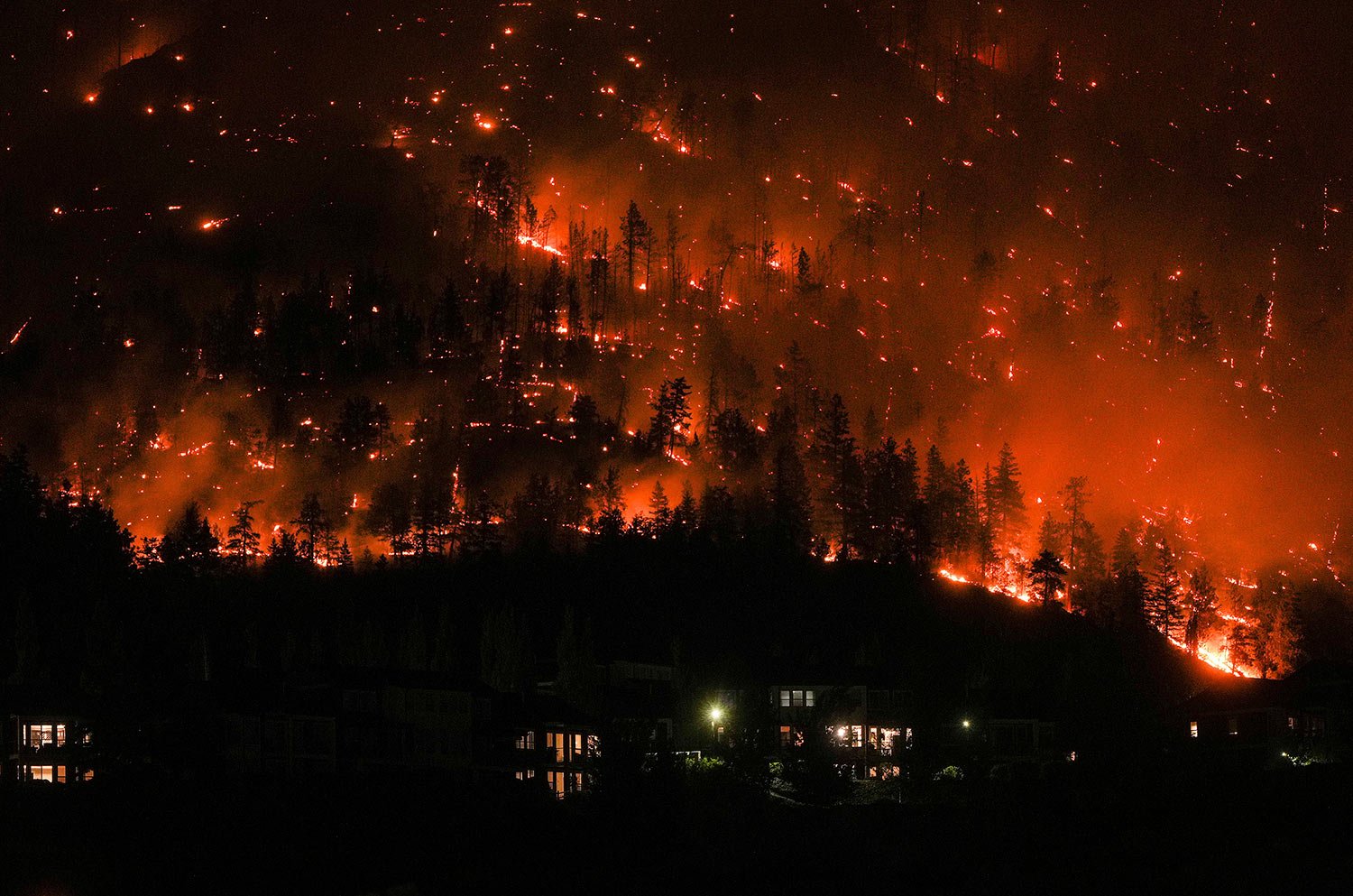  The McDougall Creek wildfire burns on the mountainside above houses in West Kelowna, British Columbia, on Aug. 18, 2023. This year was Canada's worst fire season on record. (Darryl Dyck/The Canadian Press via AP) 
