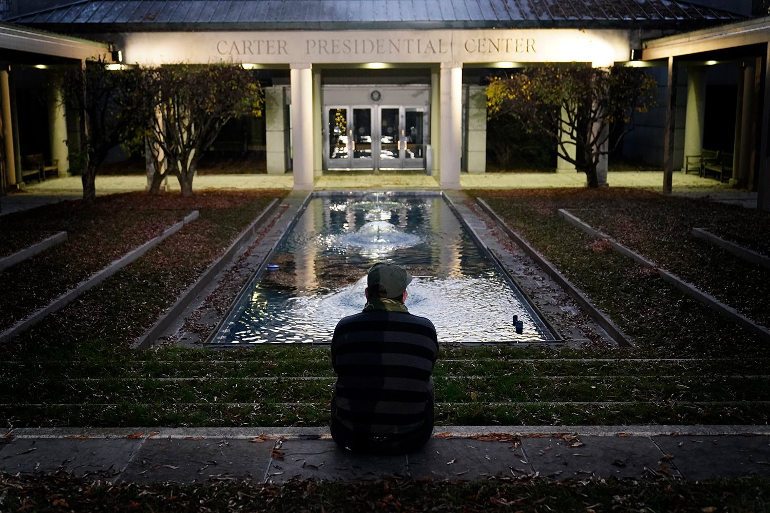  Royce Soble, of Atlanta, sits near a reflection pool at The Carter Center in Atlanta after the announcement that former first lady Rosalynn Carter had died, Sunday, Nov. 19, 2023. (AP Photo/Brynn Anderson) 