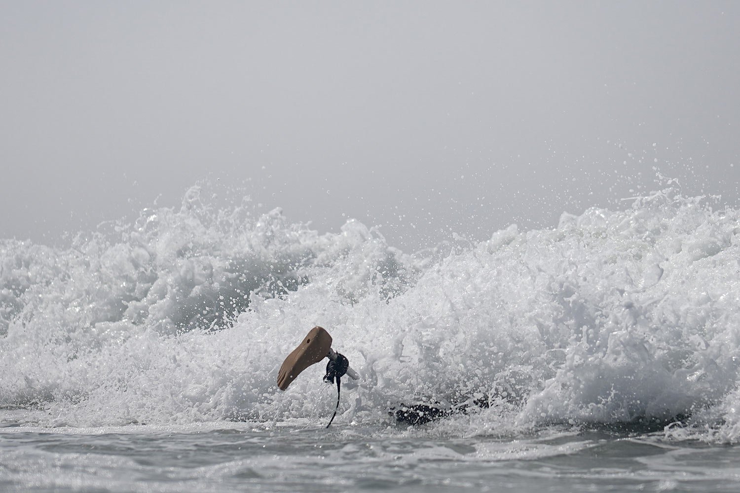  Chris Blowes, of Australia, duck-dives under a wave during the U.S. Open Adaptive Surfing Championships in Oceanside, Calif., Sept. 8, 2023. (AP Photo/Gregory Bull) 