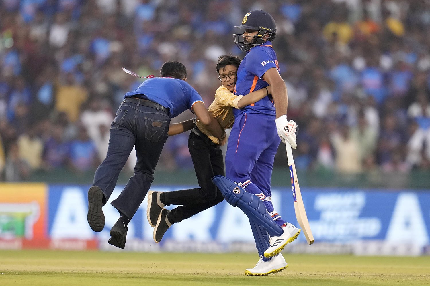  A security guard grabs a boy who invaded the field to hug India's captain Rohit Sharma, during the second one-day international cricket match against New Zealand, in Raipur, India, Jan. 21, 2023. (AP Photo/Aijaz Rahi) 