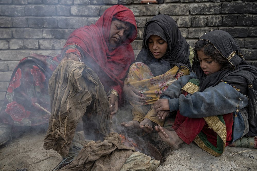  A family who were forced to leave their home, warms up by burning garbage in a camp on the outskirts of Kabul, Afghanistan, Jan 22, 2023. (AP Photo/Ebrahim Noroozi) 