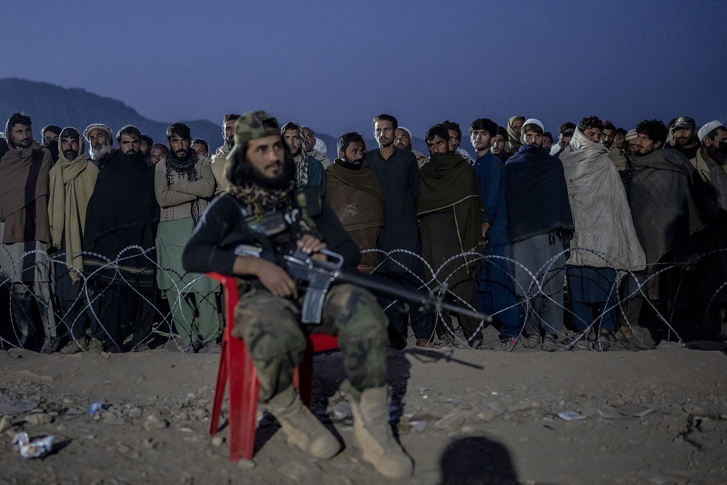  A Taliban fighter stands guard as Afghan refugees line up to register in a camp near the Pakistan-Afghanistan border in Torkham, Afghanistan, Nov. 4, 2023. (AP Photo/Ebrahim Noroozi) 