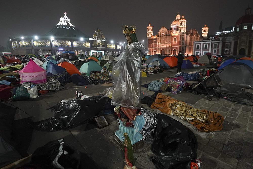  A statue of the Virgin of Guadalupe stands over pilgrims sleeping outside the Basilica of Guadalupe on her feast day in Mexico City, early Dec. 12, 2023, during one of the world's largest religious pilgrimages. (AP Photo/Marco Ugarte) 