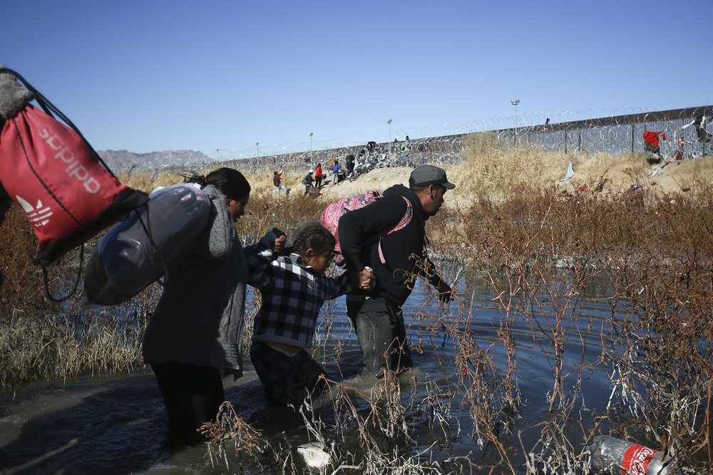  Migrants wade across the Rio Grande to reach the U.S. from Ciudad Juarez, Mexico, Dec. 27, 2023. (AP Photo/Christian Chavez) 