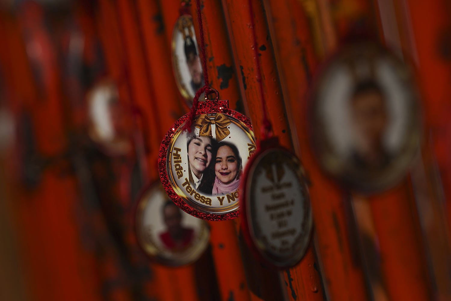  Ornaments hang from a crowd control barrier during a "posada" Christmastime procession in honor of missing relatives in Mexico City, Dec. 22, 2023. (AP Photo/Marco Ugarte) 