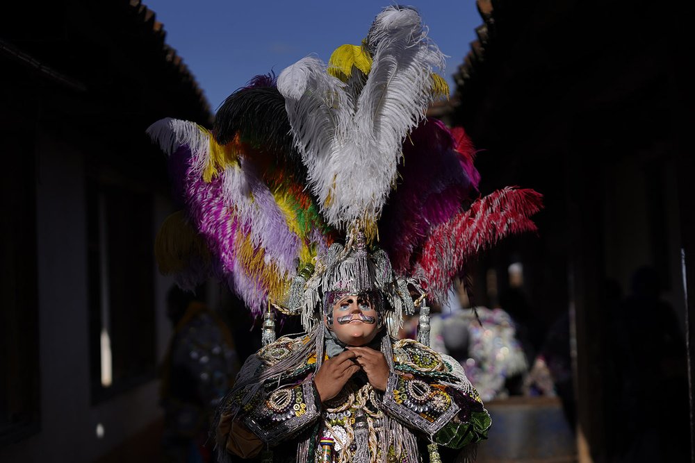  A dancer adjusts his costume before taking part in a procession honoring St. Thomas, the patron saint of Chichicastenango in Guatemala, Dec. 21, 2023. (AP Photo/Moises Castillo) 