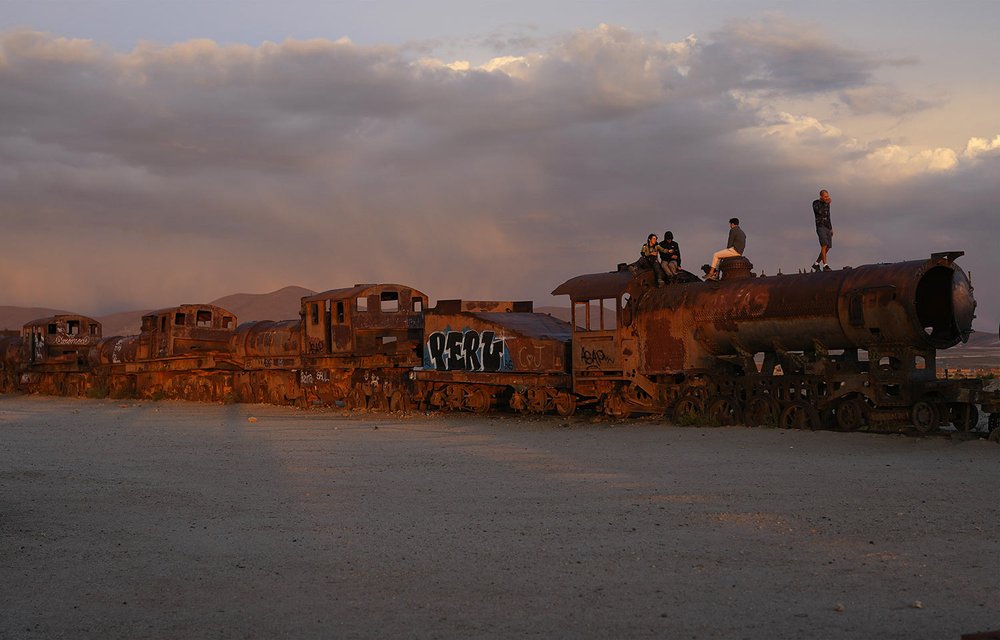  Tourists stand on an abandoned locomotive in an area commonly known as the train graveyard on the outskirts of Uyuni, Bolivia, Dec. 15, 2023. This town is the site of the country's first locomotives, which arrived in 1889. (AP Photo/Juan Karita) 
