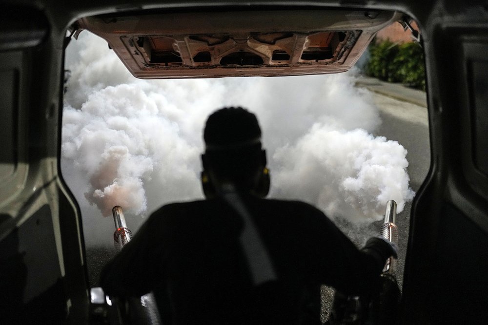  A worker fumigates a neighborhood against dengue-promoting mosquitoes in Caracas, Venezuela, Dec. 12, 2023. (AP Photo/Matias Delacroix) 