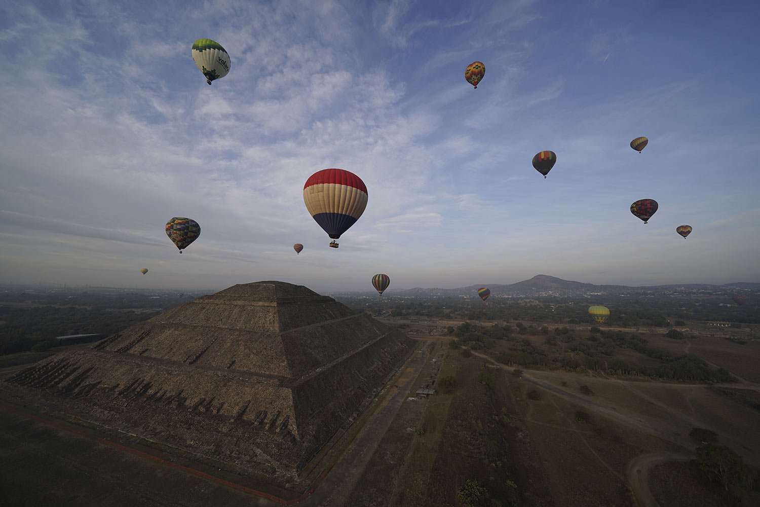  Hot air balloons fly tourists over the Sun pyramid at the Teotihuacan archaeological site, just north of Mexico City, Dec. 24, 2023. (AP Photo/Marco Ugarte) 