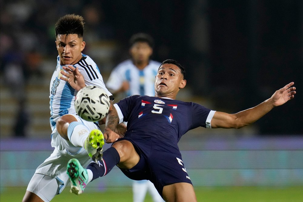  Argentina's Santiago Castro, left, and Paraguay's Gilberto Flores battle for the ball during a South America's under-23 pre-Olympic tournament soccer match in Valencia, Venezuela, Jan. 21, 2024. (AP Photo/Ariana Cubillos) 