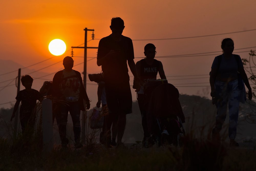  Migrants walk at sunrise along the highway through Arriaga, Chiapas state in southern Mexico, Jan. 8, 2024, during their journey north toward the U.S. border. (AP Photo/Edgar H. Clemente) 