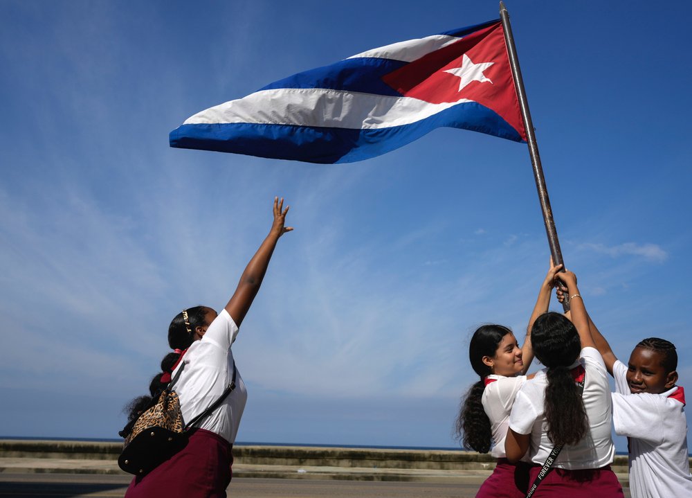  School children wave a national flag during a parade for the 65th anniversary of the arrival of Fidel Castro to the capital as head of the rebel Army in Havana, Cuba, Jan. 8, 2024. (AP Photo/Ramon Espinosa) 