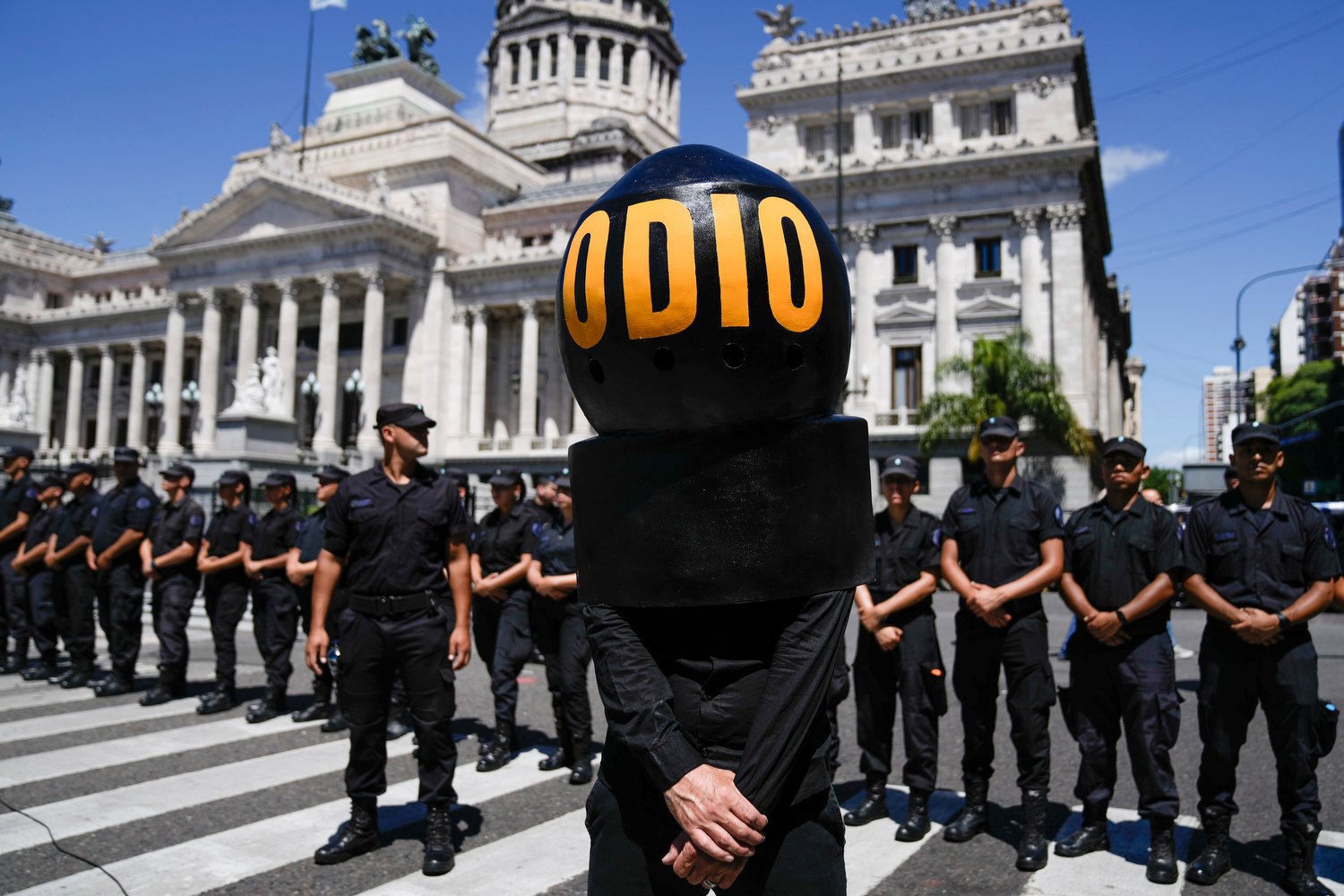  A demonstrator wearing the Spanish word "Hate" stands in front of police standing guard outside Congress as protesters rally during a national strike against the economic and labor reforms proposed by Argentine President Javier Milei in Buenos Aires