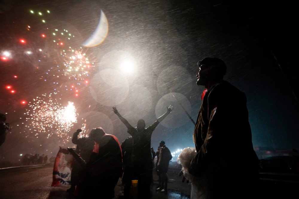  People watch fireworks while rain falls at the folk Saint "Gauchito" Gil sanctuary in Mercedes, Corrientes, Argentina, late, Jan. 7, 2024. Every Jan. 8, devotees from across the country visit his sanctuary to ask for miracles or give him thanks. (AP