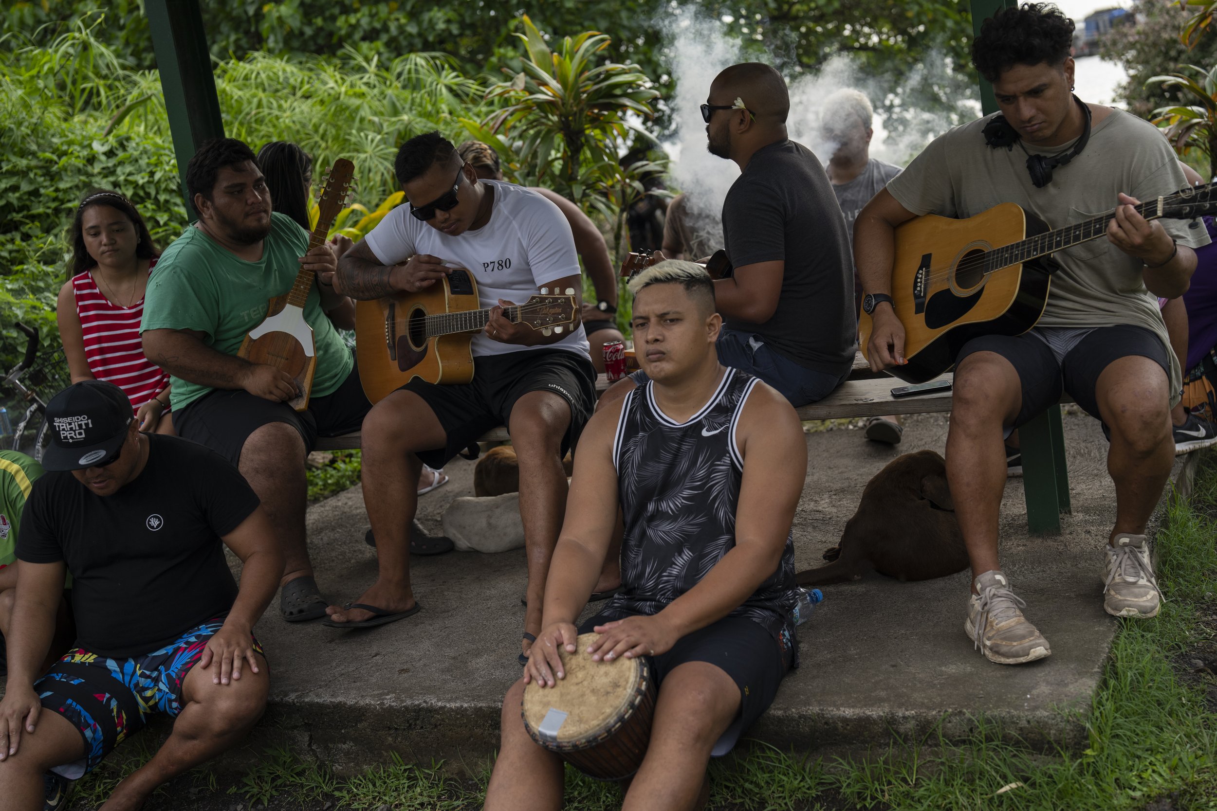  A group play music together by the side of the road in Teahupo'o, Tahiti, French Polynesia, Tuesday, Jan. 16, 2024. (AP Photo/Daniel Cole) 