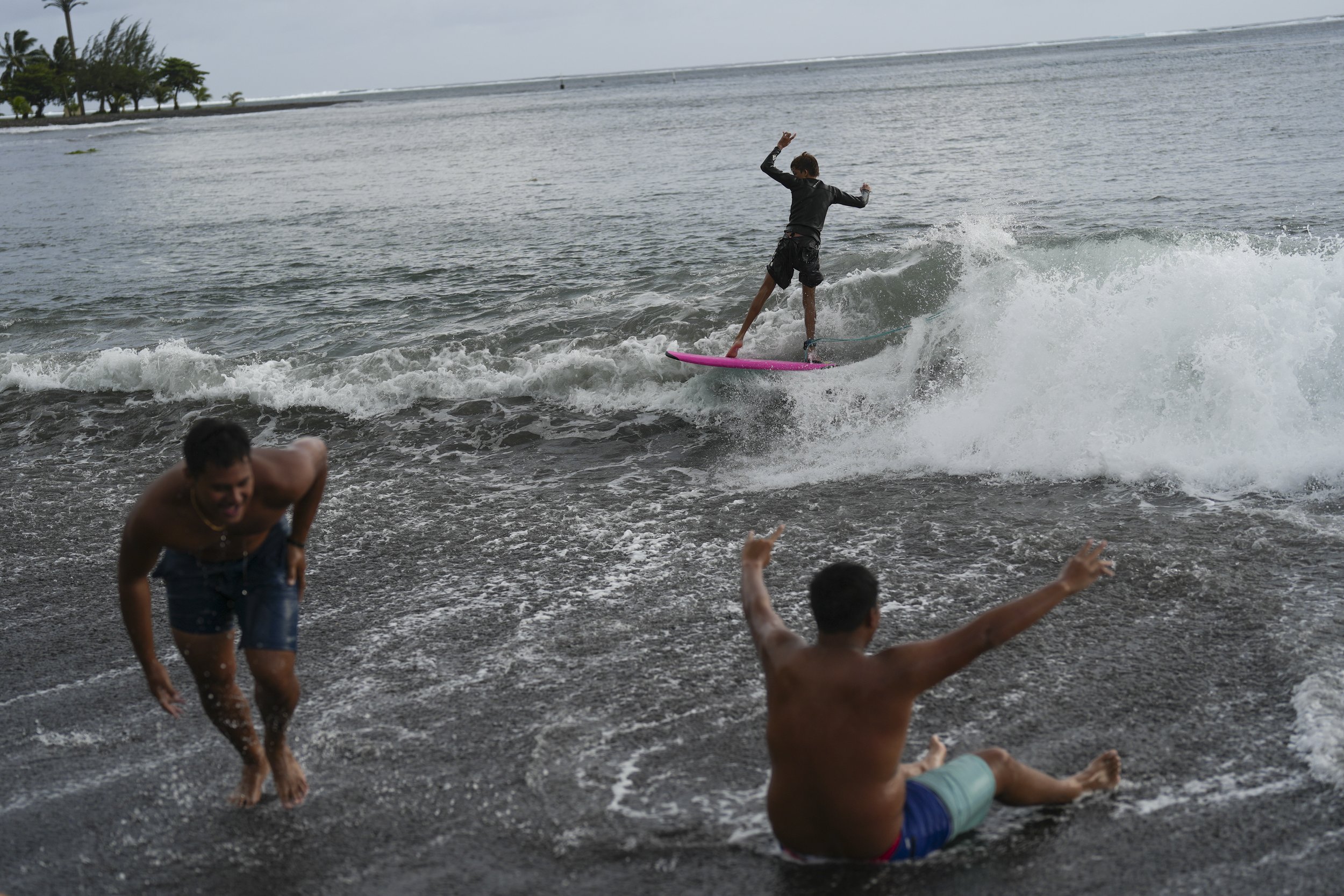  Kids surf small waves along the beach after school in Teahupo'o, Tahiti, French Polynesia, Monday, Jan. 15, 2024. (AP Photo/Daniel Cole)  